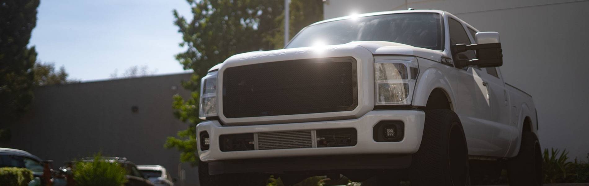 White Ford Super Duty outside the No Limit Fabrication shop