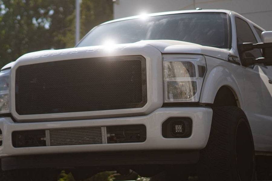 White Ford Super Duty outside the No Limit Fabrication shop